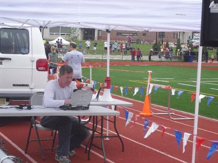 Officials recording results at a track and field event.