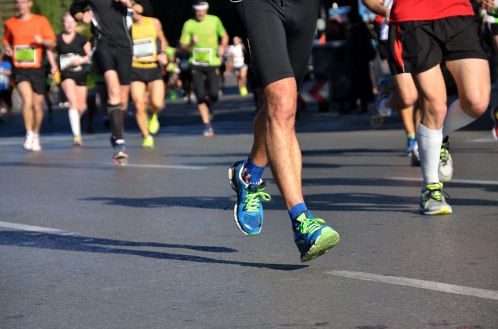 Close-up of a runner's legs and shoes during a race on a city street.